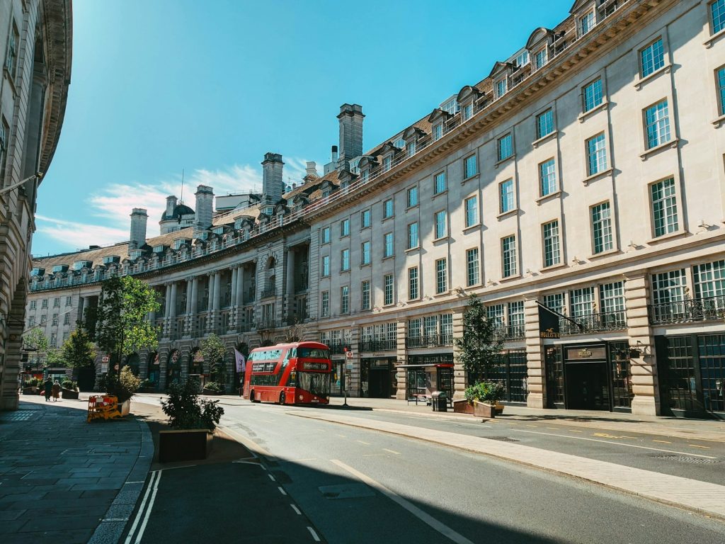 Historic architecture with a red double-decker bus in London on a sunny day