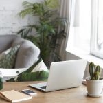 A laptop on a wooden table, surrounded by a warm and inviting living room atmosphere
