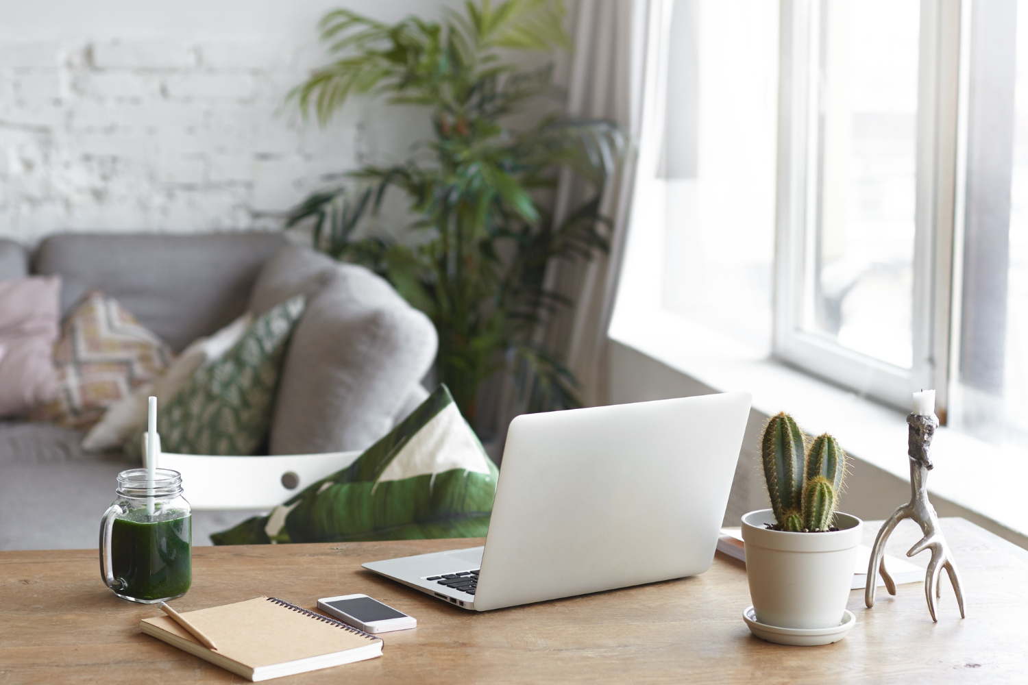 A laptop on a wooden table, surrounded by a warm and inviting living room atmosphere